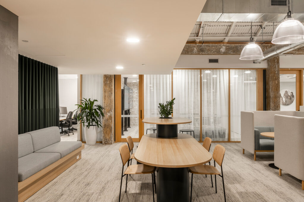 A light and airy office space with a table and four chairs in the foreground